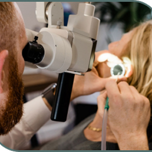 A clinician examines a patient's ear through a microscope during a hearing assessment at Almond Hearing's Livingston clinic in Scotland.